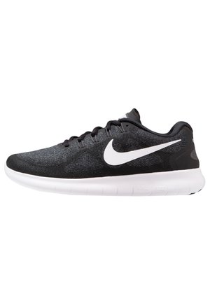 Schwarzer Nike Laufschuh mit weißem Swoosh-Logo und flexibler weißer Sohle, Seitenansicht, zeigt Schnürsenkel und gepolsterten Kragen.