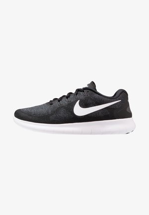 Chaussure de course Nike noire avec logo swoosh blanc et semelle blanche flexible, vue latérale montrant les lacets et le col rembourré.