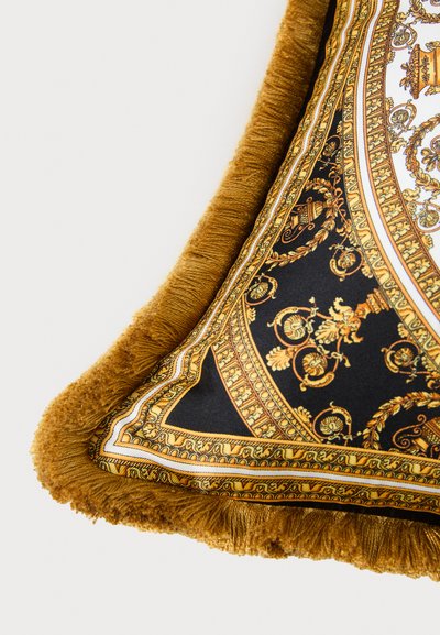 Γωνία διακοσμητικού μαξιλαριού με περίπλοκο μοτίβο μπαρόκ σε χρυσό και μαύρο, με χοντρή κίτρινη φουντίτσα στα άκρα.
