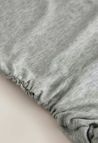 Grauer, gerippter Stoff mit strukturierter Oberfläche und gerafftem elastischem Saum. Weiches Material, geeignet für Freizeitkleidung oder Loungewear.