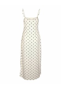 Robe maxi blanche sans manches avec fines bretelles ajustables et motif à pois noirs partout.