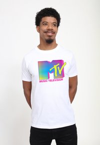 White cotton t-shirt featuring a multicolored MTV logo in retro style, with "MUSIC TELEVISION" text in pink below the logo.