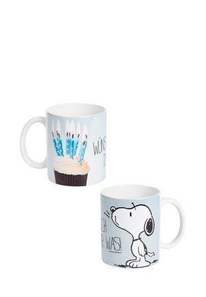 White mugs with birthday design; one shows a cupcake with lit blue candles, the other features Snoopy cartoon and partial German text.