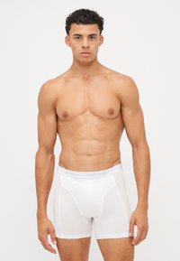 Boxeri albi dintr-un material neted, cu un brâu logo gri. Designul este ajustat, oferind o siluetă strânsă.