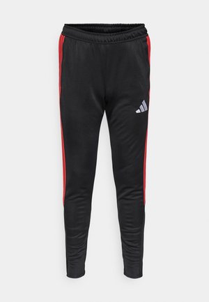 Black athletic pants with red side stripes and an elastic waistband. Features a small grey logo on the left leg. Smooth, lightweight material.