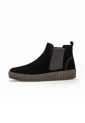 Des bottines noires en daim présentent une semelle plate-forme texturée, des panneaux latéraux élastiques en chevron gris et une tirette au niveau du talon.