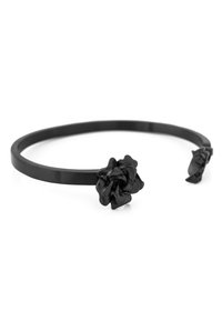 Black metal cuff bracelet featuring a rose design at one end and a leaf accent at the other. Smooth finish with textured floral details.