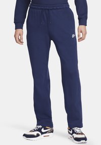 Námořnické modré tepláky Nike vyrobené z materiálu s příměsí bavlny, s elastickým pasem, bočními kapsami a malou bílou logovou akcentací.