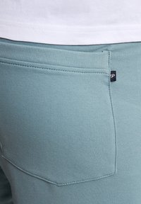 Lichtblauwe sweatpants met een geribde tailleband, een achterzak met een klein logo-label en een gestructureerde stofafwerking.