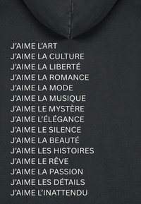 Felpa grigia scura con cappuccio, caratterizzata da testo bianco che elenca diverse frasi che iniziano con "J'aime" (Io amo) in francese, con cappuccio regolabile.