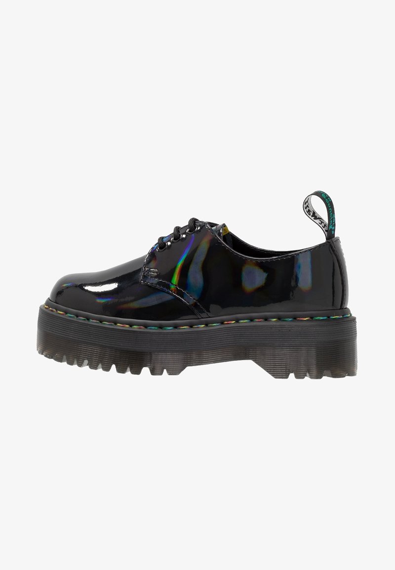 Chaussure à lacets en cuir verni noir avec semelle épaisse et robuste, surpiqûres arc-en-ciel autour de la semelle et languette de tirage estampillée au talon.
