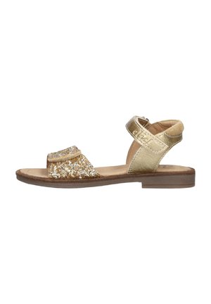 Kindersandalen met een platte zool, een voorband met goudkleurige glitters, een metallic gouden enkelband met klittenbandsluiting en een bruine zool.