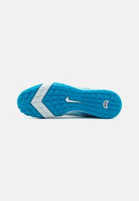 Suela de zapato Nike en azul y blanco con un patrón de agarre texturizado y el logo del swoosh de Nike en el centro sobre un fondo blanco.