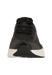 Zapatilla atlética negra con parte superior texturizada, puntera redonda, cordones negros y suela blanca. Presenta un diseño estampado y acentos de goma.
