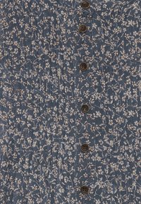 Vestido azul con estampado floral, confeccionado con una tela textured, adornado con cinco botones marrones en la parte frontal para el cierre.