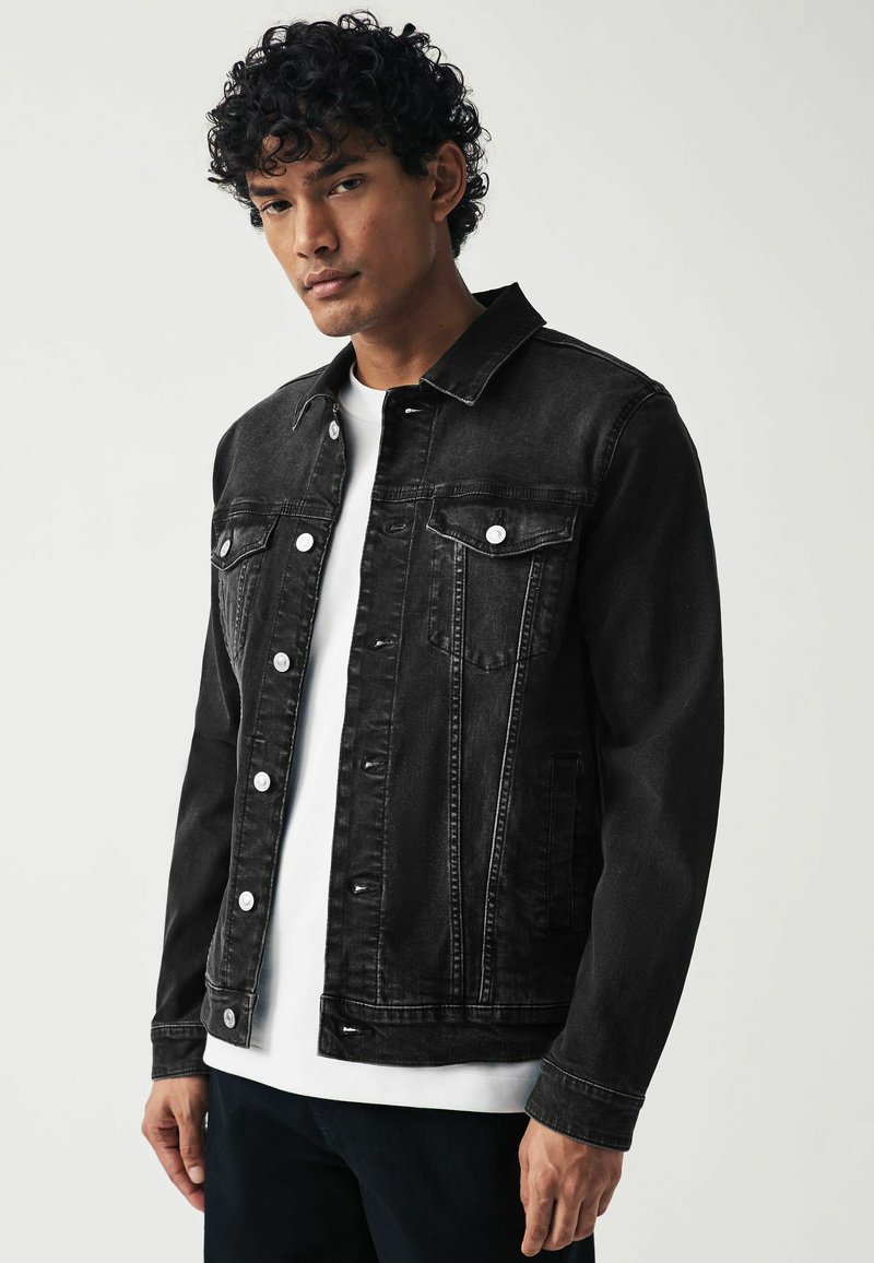 Schwarze Jeansjacke mit Knopfleiste, zwei Brusttaschen und klassischem Kragen. Verfügt über einen entspannten Schnitt und robusten Nähten.