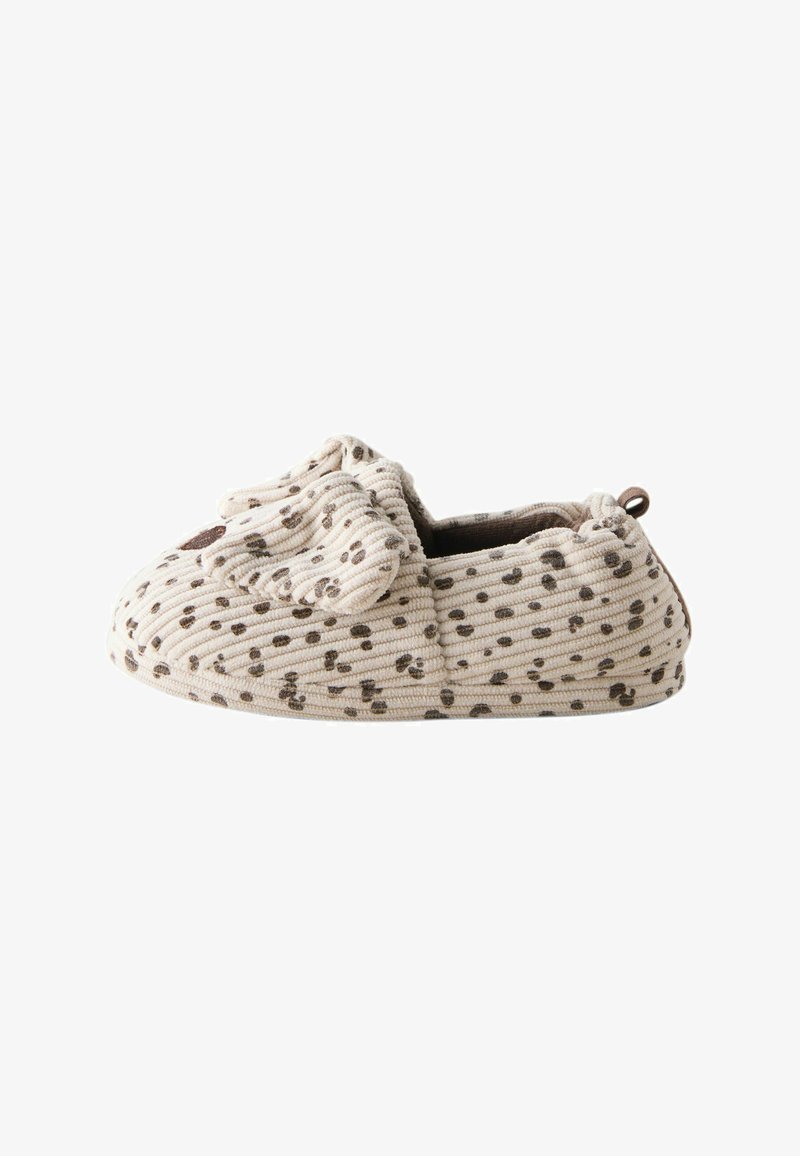 Chausson bébé beige doux avec des taches brunes, un tissu côtelé texturé et un petit motif de visage d'animal à l'avant.