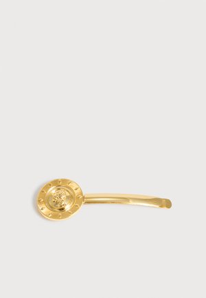 Épingle à cheveux en métal doré avec un médaillon décoratif rond présentant un motif en relief de tête de lion classique.