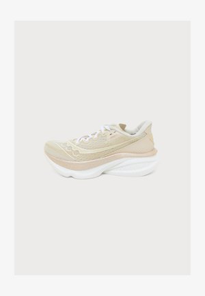 Chaussure de course beige et blanche avec une semelle épaisse et rembourrée et des lacets blancs, conçue pour un usage sportif, montrée de profil sur un fond neutre.