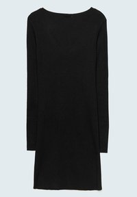 Robe en maille noire à manches longues avec un col rond, une silhouette droite et un ourlet au-dessus du genou sur un fond clair.