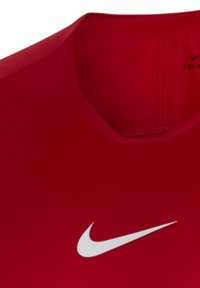 Rotes Nike Dri-FIT Sportshirt im Nahaufnahme, mit rundem Ausschnitt, kurzen Ärmeln und einem auffälligen weißen Swoosh-Logo. Glatte Textur.