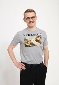 Šedé bavlněné tričko s velkým grafickým potiskem Michelangelova umění, s tučným textem "MICHELANGELO" nad obrázkem.