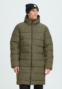 Garšs, olīvu zaļš pildīts mētelis ar augstu apkakli, priekšējo rāvējslēdzēju un divām sānu kabatām. Iekļauj kapuci un horizontālu quilted dizainu.
