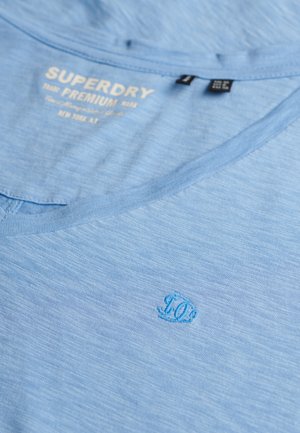 Lyseblå bomulds T-shirt med V-hals. Har et diskret, broderet "10" logo nederst til højre. Blød tekstur med meleret mønster.