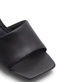 Zwarte leren open teen sandalen met een brede band over de wreef, vierkant gevormde teen en een gladde textuur.