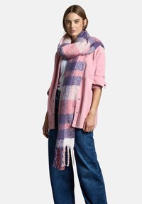 Flerfarvet plaid-scarf med rosa, lilla og creme nuancer, lavet af blødt materiale, med frynser i enderne.