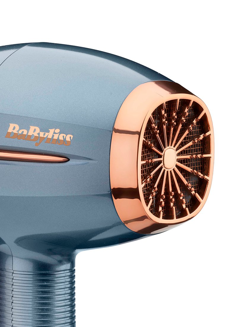 BaByliss Haartrockner in metallic Blau mit glänzender Oberfläche und Kupferakzenten. Verfügt über eine runde Düse mit einem Gittermuster.