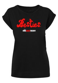 Juodas medvilninis marškinėliai su apvyniotomis rankovėmis, su raudonais žodžiais "Besties" ir balta logotipo "the BIG BANG THEORY" užrašu apačioje.