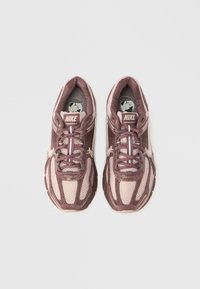 Αθλητικά παπούτσια Nike Vomero σε αποχρώσεις του ροζ και μαβί, με υλικό από δίχτυ, σύστημα κορδονιών, επενδυμένο κολάρο και αντανακλαστικές λεπτομέρειες.