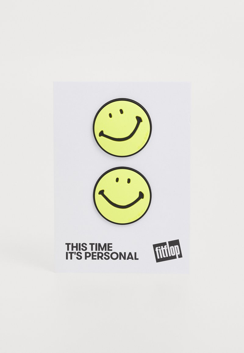 Dois alfinetes redondos com sorrisos amarelos brilhantes, contornos pretos e um acabamento brilhante, exibidos em um cartão branco com texto preto.