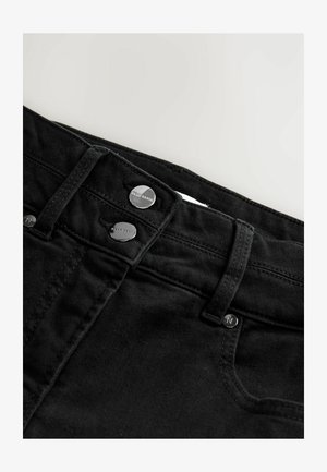 Des jeans en denim noir présentent une texture lisse, deux boutons argentés à la taille et un design classique à cinq poches.