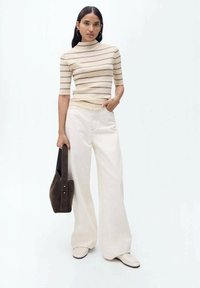 Beige gestreepte top met korte mouwen, relaxte crème wijde broek en donkerbruine suède handtas. Gladde textuur, eenvoudig ontwerp en neutrale kleuren.