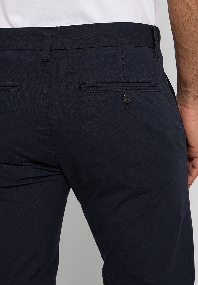 Granatowe bawełniane spodnie o prostym kroju, z tylną kieszenią zapinaną na guzik oraz teksturowanym materiałem, co zapewnia trwałe wykończenie.
