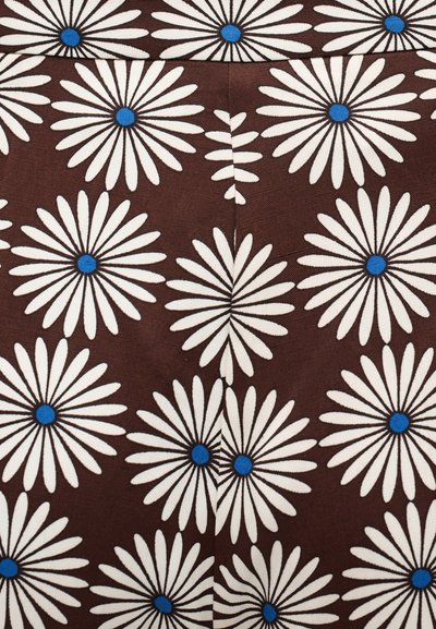 Καφέ ύφασμα με επαναλαμβανόμενο μοτίβο μεγάλων λευκών μαργαριτών με μπλε κέντρα, τοποθετημένα σε σχέδιο που θυμίζει πλέγμα.
