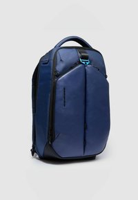 Zaino blu con fronte in tessuto testurizzato, dettagli in pelle liscia, manico superiore e chiusura centrale con zip. Dotato di spallacci regolabili.