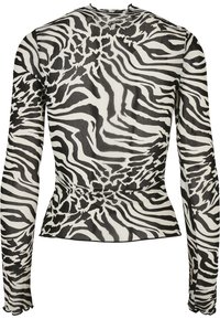 Långärmad topp med ett genomskinligt tyg med ett svart och vitt zebramönster, figursydd design och en peplum-silhouette vid midjan.