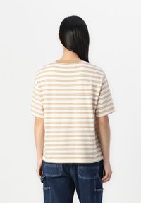 Striped short-sleeve t-shirt in cream and tan, round neck, relaxed fit, made of soft cotton, featuring horizontal lines and a straight hem.