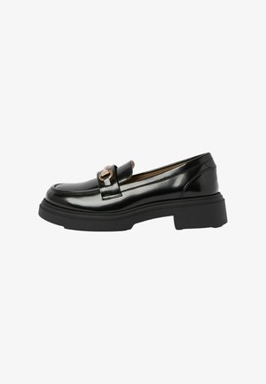 Mocasin din piele lacuită neagră cu talpă neagră groasă, având un accesoriu auriu în formă de cataramă pe partea superioară și un finisaj neted și lucios.