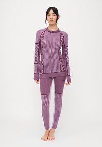 Lila sportos szett, texturált, hosszú ujjú felsővel és testhez simuló leggings-szel, változatos mintákkal és csíkokkal. Rugalmasságot biztosító anyagból készül.