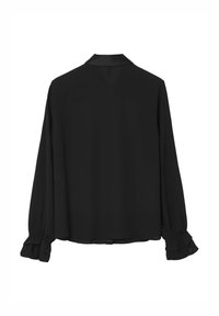 Blouse noire à manches longues, en tissu doux, avec col et détails de volants froncés aux poignets. Silhouette simple et structurée.