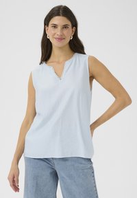 Haut sans manches bleu clair avec un décolleté en V et une bordure en dentelle festonnée. Tissu doux et texturé avec une coupe décontractée et un drapé subtil.