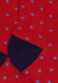 Calze rosse in maglia con piccoli pois lavanda e talloni e punte rinforzati di un blu navy scuro.