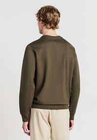 Sweatshirt verde oliva in tessuto morbido, con scollatura rotonda e maniche lunghe, bordato in costina su fondo e polsini.