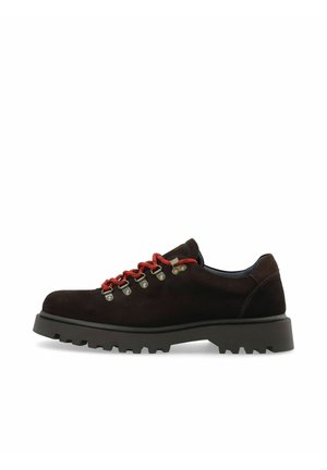Chaussure de randonnée en daim brun foncé avec une semelle épaisse à crampons noire et des lacets rouges passés dans des œillets métalliques sur fond blanc.