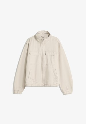 Beżowa kurtka zapinana na zamek z wysokim kołnierzem, dwiema kieszeniami na klatce piersiowej z klapkami, dwiema kieszeniami bocznymi, elastycznymi mankietami i elastycznym dołem na białym tle.