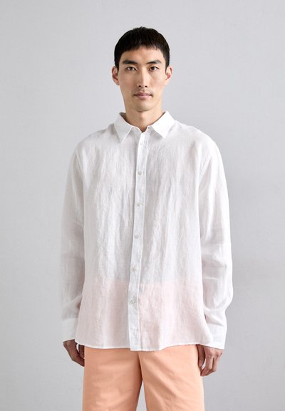 Chemise en lin blanc avec un devant boutonné, des manches longues et un dégradé rose subtil à l'ourlet. Texture lisse et coupe décontractée.